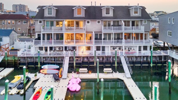 A waterfront property with a dock, kayaks, and a paddleboard. - Stunning Water Views - Fireplace - Chelsea Harbor (Atlantic City)