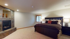 A bedroom with a large bed, a fireplace, and a window. - Family Oasis with Access to The Cove (Sunriver)