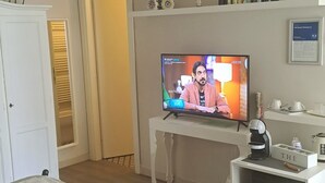 Une chambre d’hôtel équipée d’un lit, d’une télévision, d’une machine à café et d’un mini-bar.