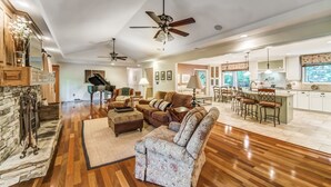 A spacious living room with a fireplace, a dining area, and a kitchen.