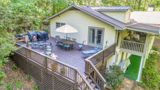A house with a deck, outdoor furniture, and a covered patio area.