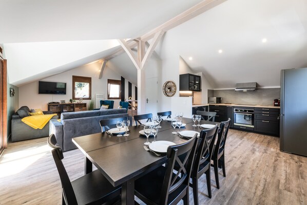 Un apartamento moderno estilo loft con comedor, cocina y sala de estar.
