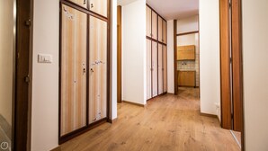 Un corridoio con pavimento in legno e porte scorrevoli decorate con motivi floreali.