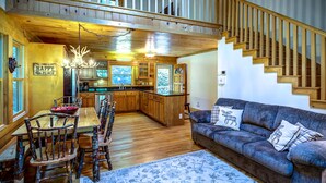 A cozy cabin interior with a dining area, kitchen, and a staircase. - Closest cabin to Tweetsie. BEST Blowing Rock Location!  Hot tub & game room (Blowing Rock)
