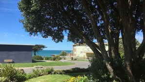 A residential area with a house, a tree, and a view of the ocean. - 150  Steps to Beach with EV Charging (Apollo Bay)