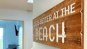 A wooden sign with the text 'Life is better at the beach' mounted on a wall. - Apollo Ocean Blue Ocean View Wi-Fi Pet Friendly (Apollo Bay)
