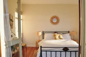 Cozy retreat with a large bed, two bedside tables, and a decorative wall hanging.
