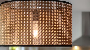 Une cuisine moderne dotée d’un îlot central, de luminaires suspendus et d’une cuisinière visible.
