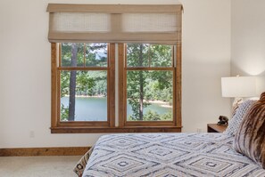 A bedroom with a large window offering a view of a lake and trees. - 65 Southshore Drive Lodge 3 at Bear Lake Reserve (Tuckasegee)