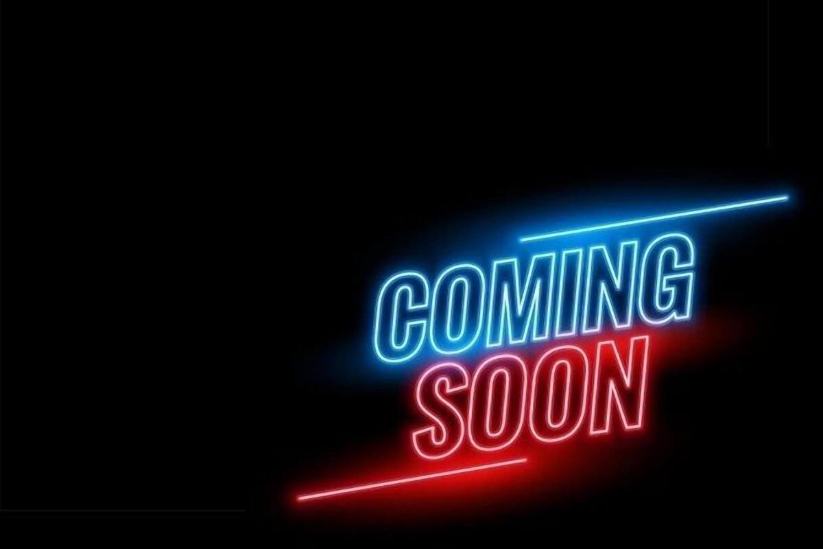 A neon sign with the words "COMING SOON" in blue and red.