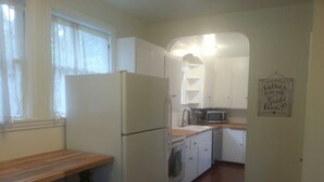 A compact kitchen with white appliances, a wooden countertop, and a small stool. - Craftsman Duplex in Old Town Issaquah - Free Wi-Fi (Issaquah)
