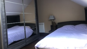 Una camera da letto con due letti, un comodino, una lampada e uno specchio.