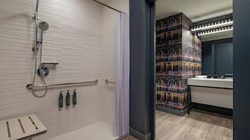 Un bagno moderno con doccia a filo pavimento, un mobile lavabo decorato con un murale raffigurante un panorama cittadino e un pavimento in legno.