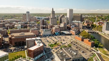 Une vue aérienne d’une ville, avec différents bâtiments, un parking et une rivière.