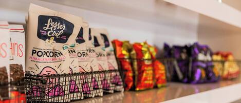 A shelf with various snack packages, including popcorn and other snacks.