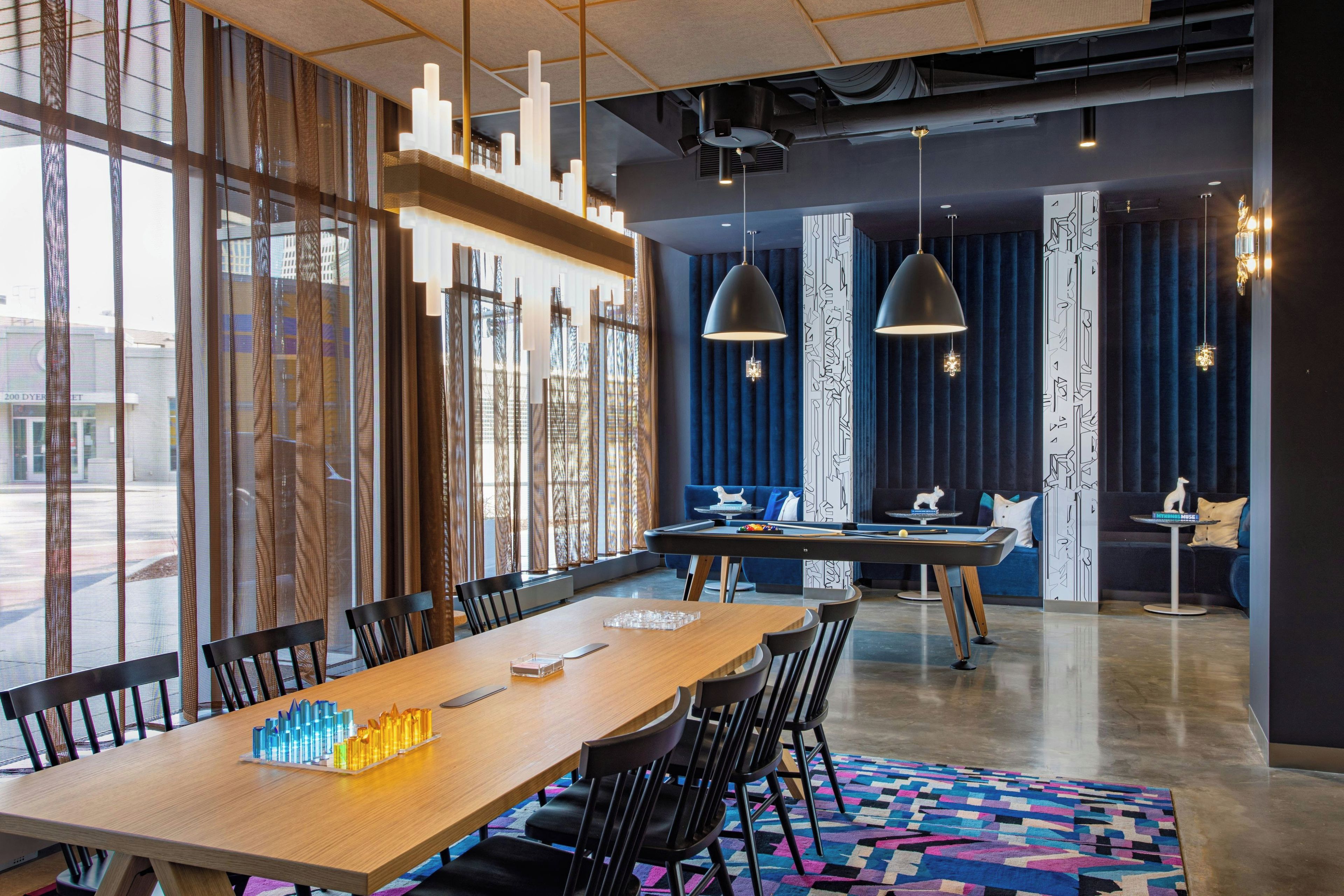 Une salle de conférence moderne, dotée d’une longue table, de chaises et d’une table de billard.