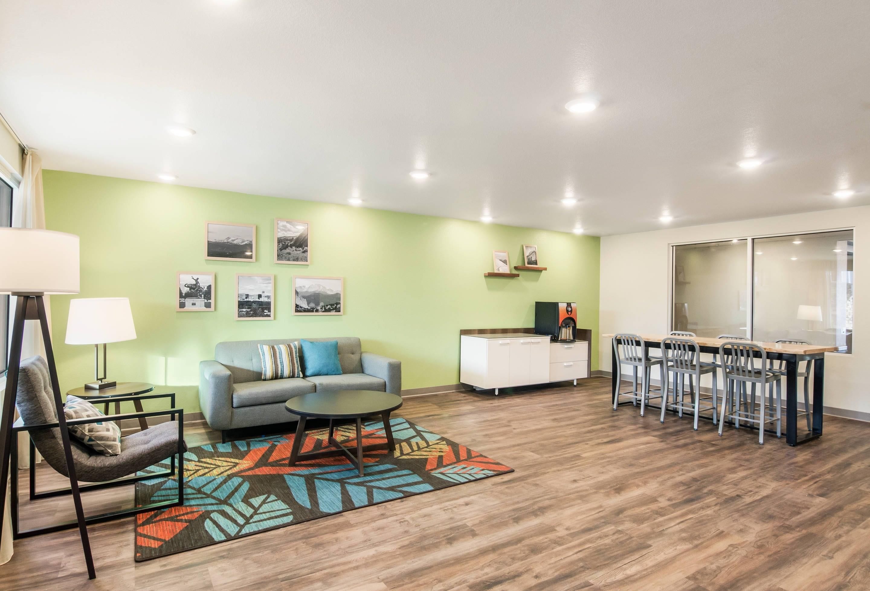 Una sala de estar moderna con un sofá, una mesa de centro y un comedor con sillas y una mesa.