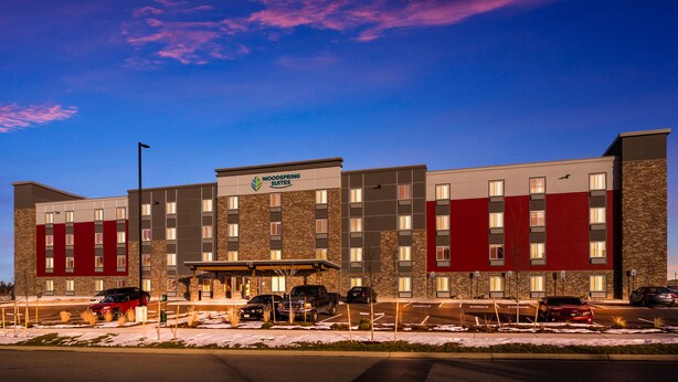 A multi-story hotel with a modern design, featuring a prominent sign for "Woodspring Suites." - WoodSpring Suites Thornton-North Denver (Thornton)