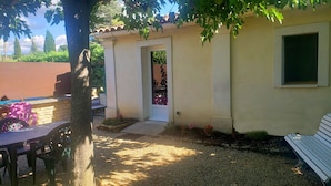 A house with a patio area, a table, and chairs. - Cottage at the foot of the Luberon + Garden and private swimming pool (Robion)