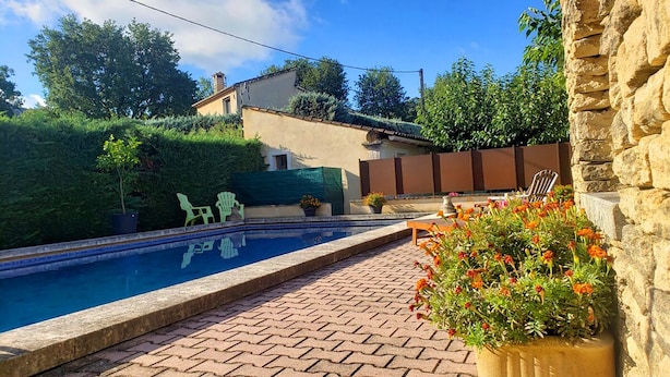 A swimming pool with a brick patio, surrounded by greenery and a stone wall. - Cottage at the foot of the Luberon + Garden and private swimming pool (Robion)