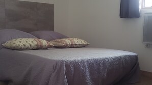 A bedroom with a bed, a headboard, a window with curtains, and a wall-mounted air conditioner. - Cottage at the foot of the Luberon + Garden and private swimming pool (Robion)