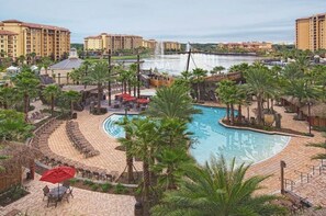 Relax by the resort's oval-shaped pool surrounded by palm trees and lounge chairs.