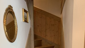 A wooden staircase with a white wall and a gold-framed mirror. - D305 - 73m2 - 4P - 8/10 pers (Prapoutel)