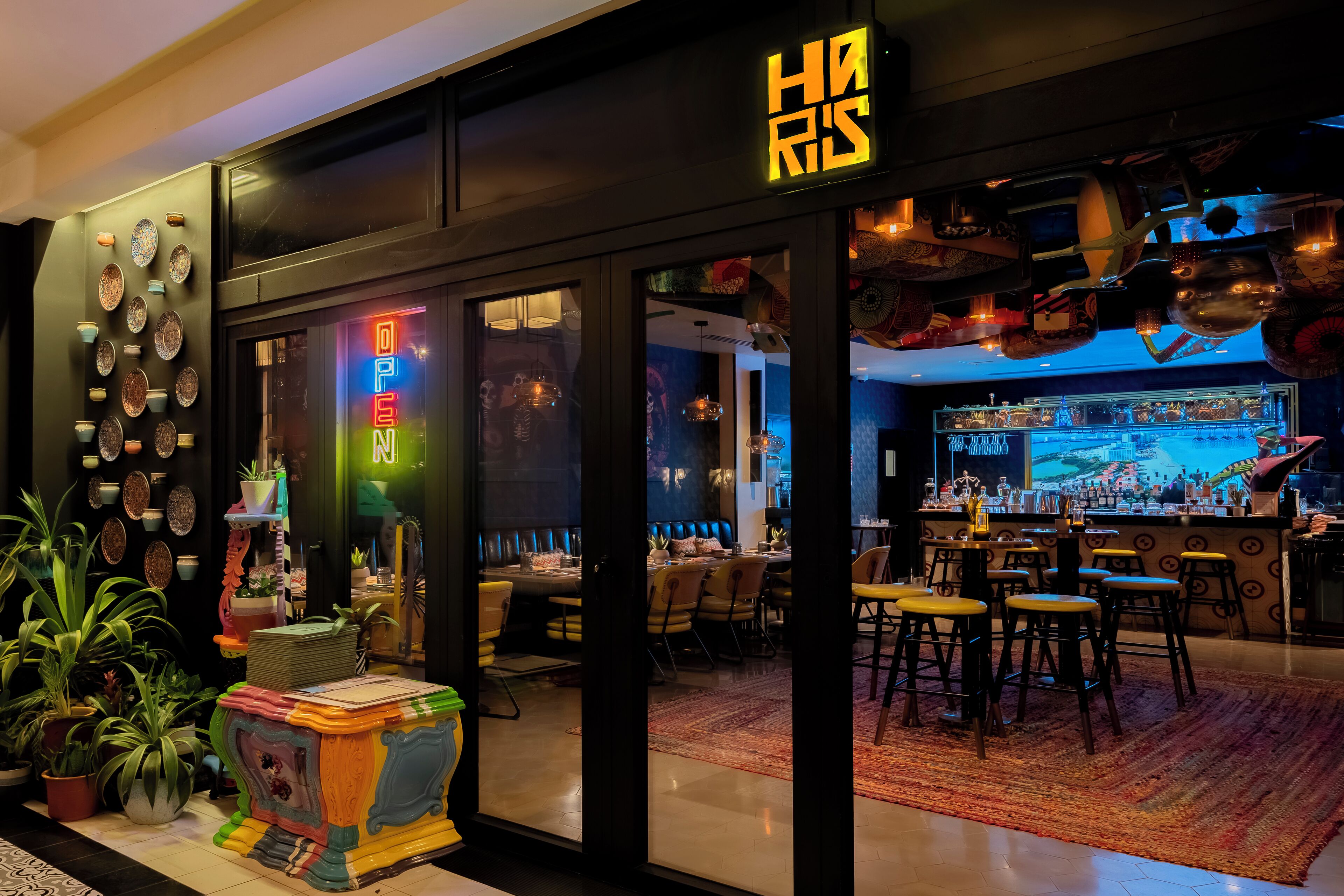 Un ristorante con insegna al neon, un'area bar e diversi elementi decorativi alle pareti.