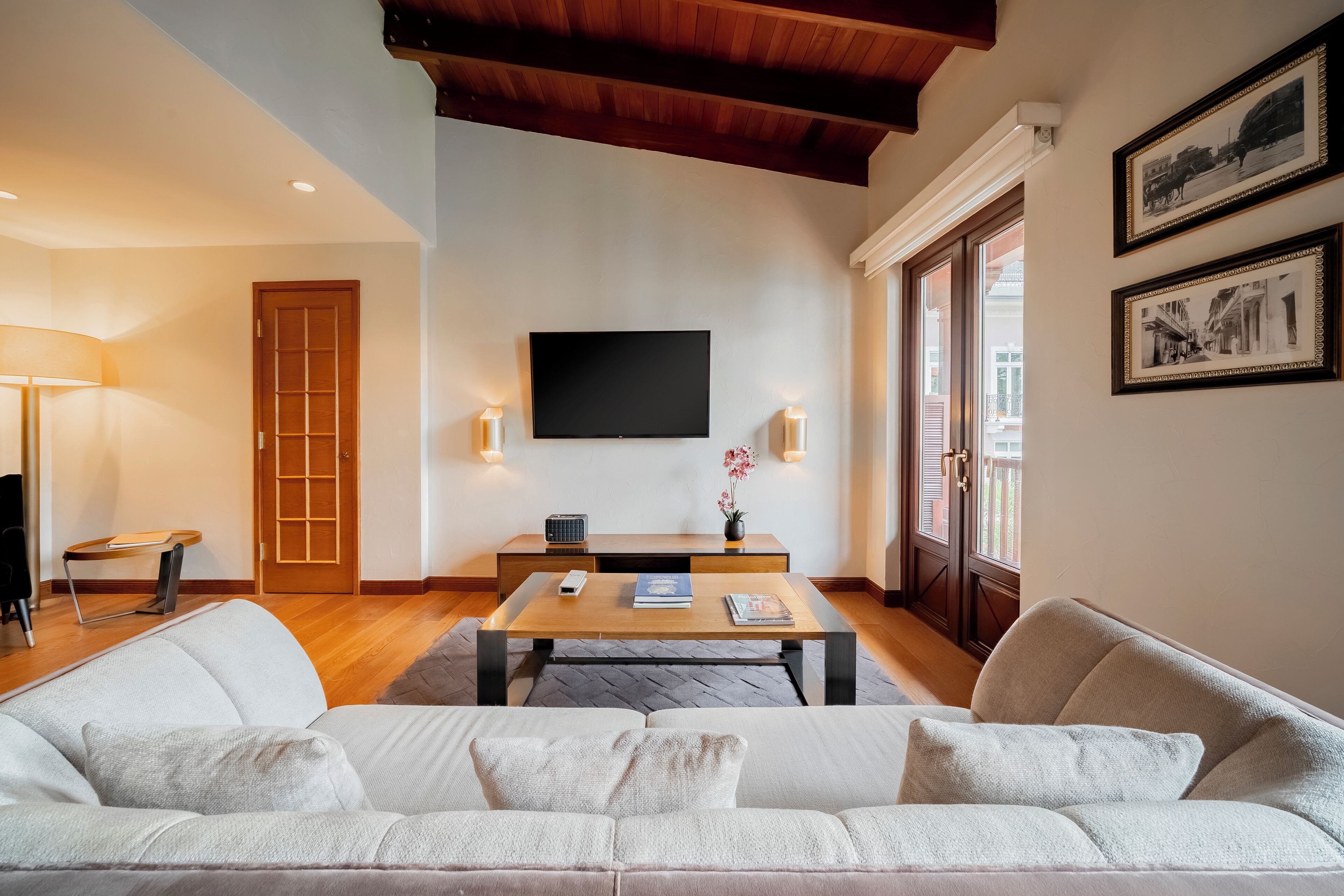 Un salon moderne avec un canapé, une table basse, un téléviseur et une porte.