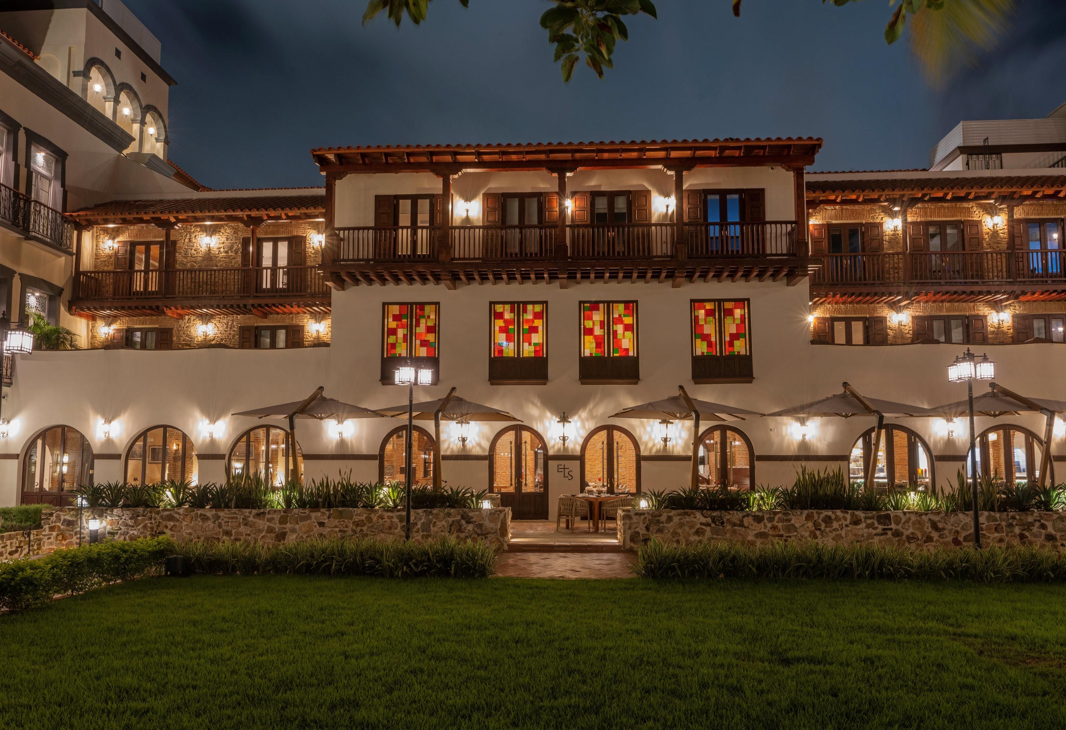 Un edificio de varios pisos con balcones, ventanas de arco y zonas de estar al aire libre.