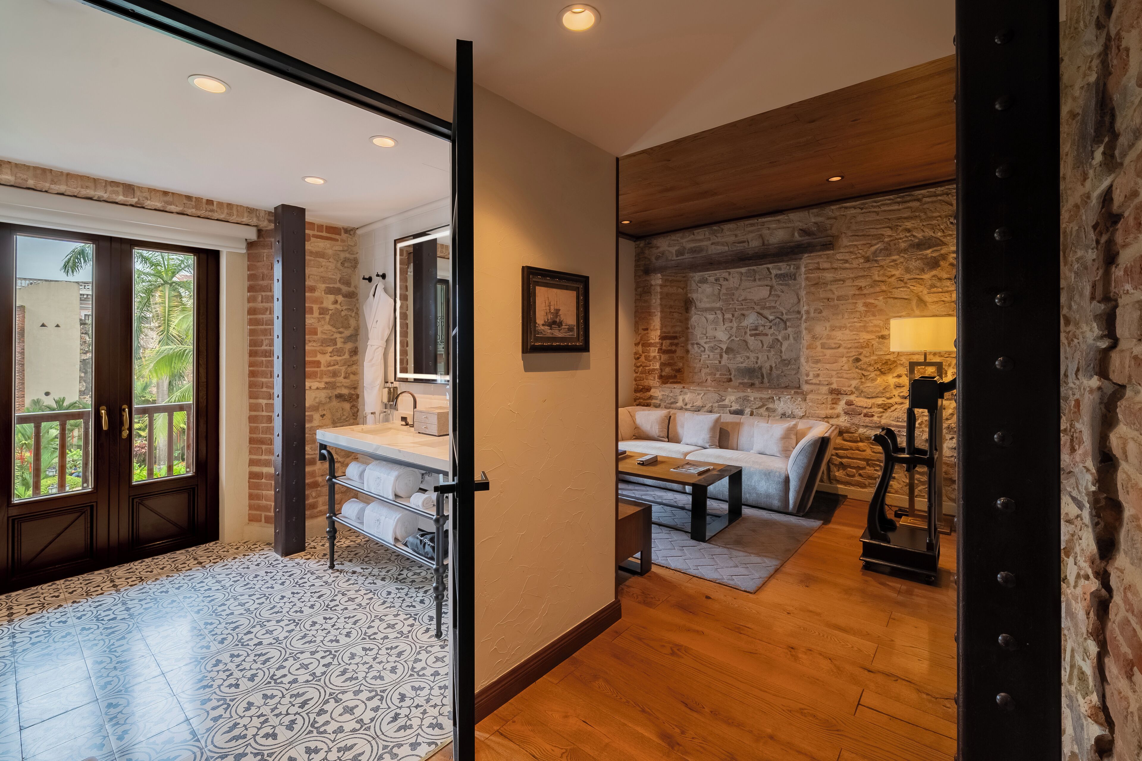 Una sala de estar moderna con una pared de piedra, un sofá, una mesa de centro y una lámpara.