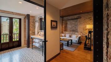 Una sala de estar moderna con una pared de piedra, un sofá, una mesa de centro y una lámpara.