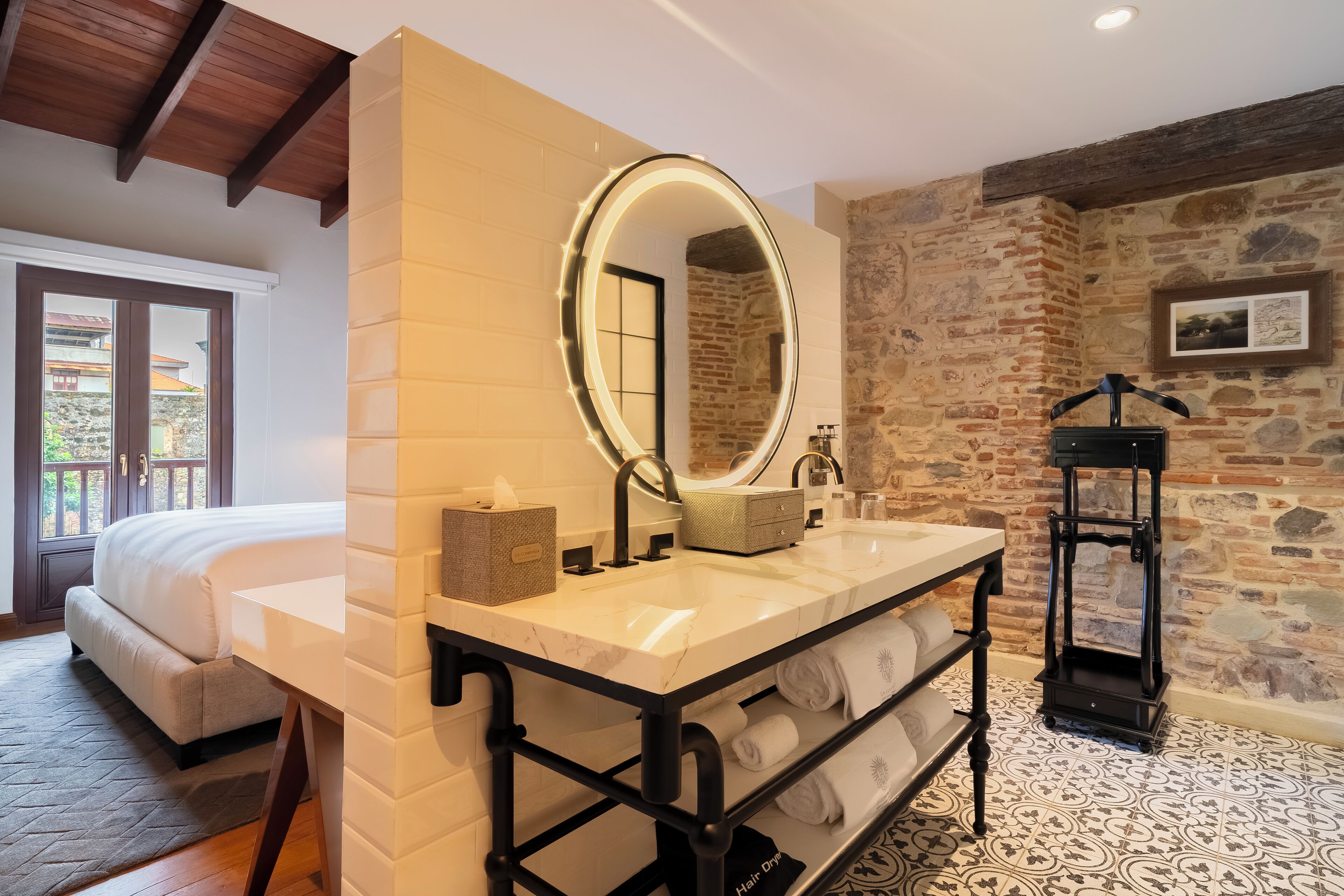 A bathroom with a large mirror, a sink, and a towel rack.