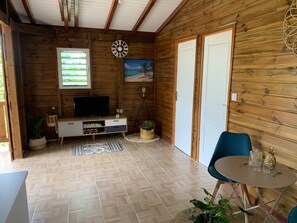 Relax in a well-appointed room with a flat-screen TV, comfortable seating area, and a large window offering a view of the surrounding greenery.