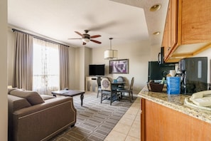 Relax in this cozy space with a sofa, TV, and kitchenette featuring a refrigerator, microwave, and coffee machine.