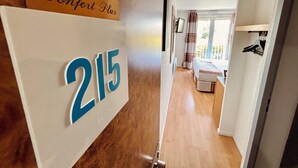 A hallway with a sign reading "Confort Plus" and the number "215".