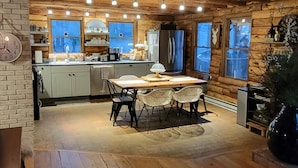 A cozy cabin-style kitchen with wooden beams, a dining area, and a large window. - 
Your Mountain Cabin Getaway Awaits! (Wintergreen)