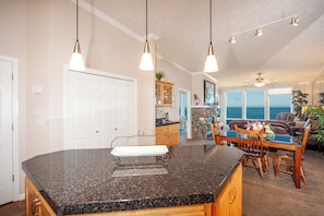Relax in this spacious living area with a large kitchen island, dining area, and ocean views.
