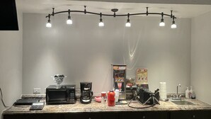 Une cuisine équipée d’un long comptoir, d’un four à micro-ondes, d’une machine à café et d’un évier.