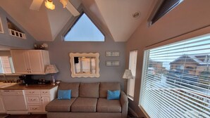 A cozy living area with a sofa, a coffee machine, and a dining table.