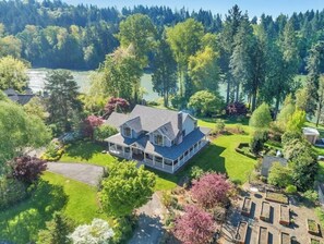 Situated in a lush landscape, this house features a well-maintained lawn and a variety of mature trees.