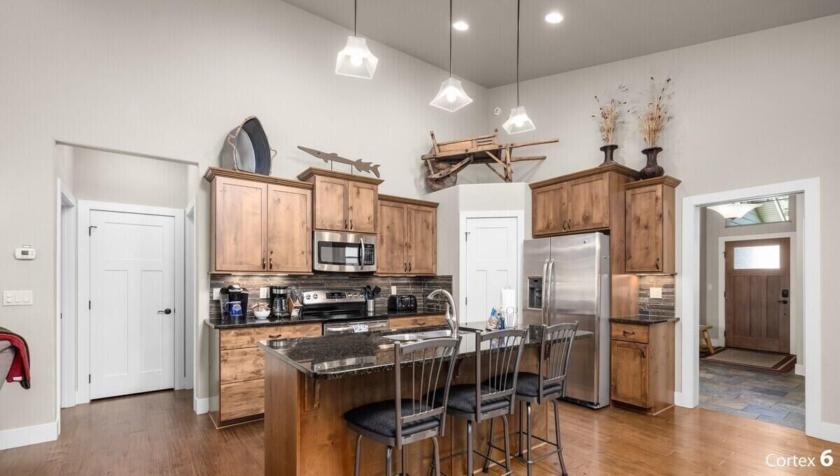 A modern kitchen with wooden cabinets, stainless steel appliances, and a central island with bar stools.