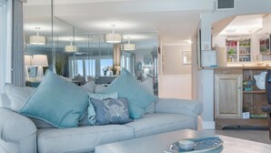 Una sala de estar moderna con un sofá gris, cojines decorativos y una mesa de centro.