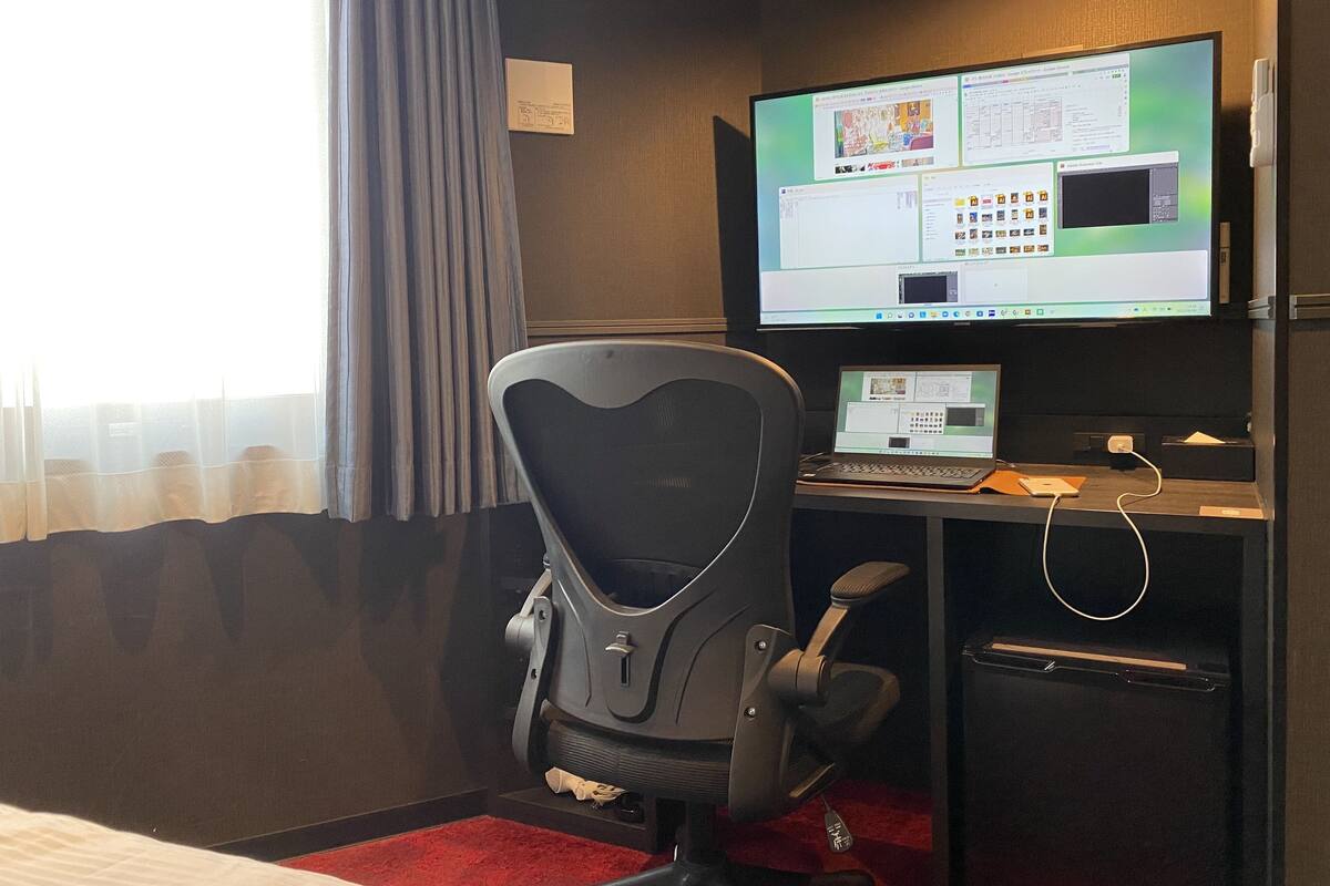 Une chambre d  ’hôtel équipée d’un bureau, d’un ordinateur et d’une chaise.