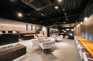 A modern restaurant with a bar area, seating arrangements, and a reception desk. - mizuka Business Canalcity Hakata mae (Fukuoka)
