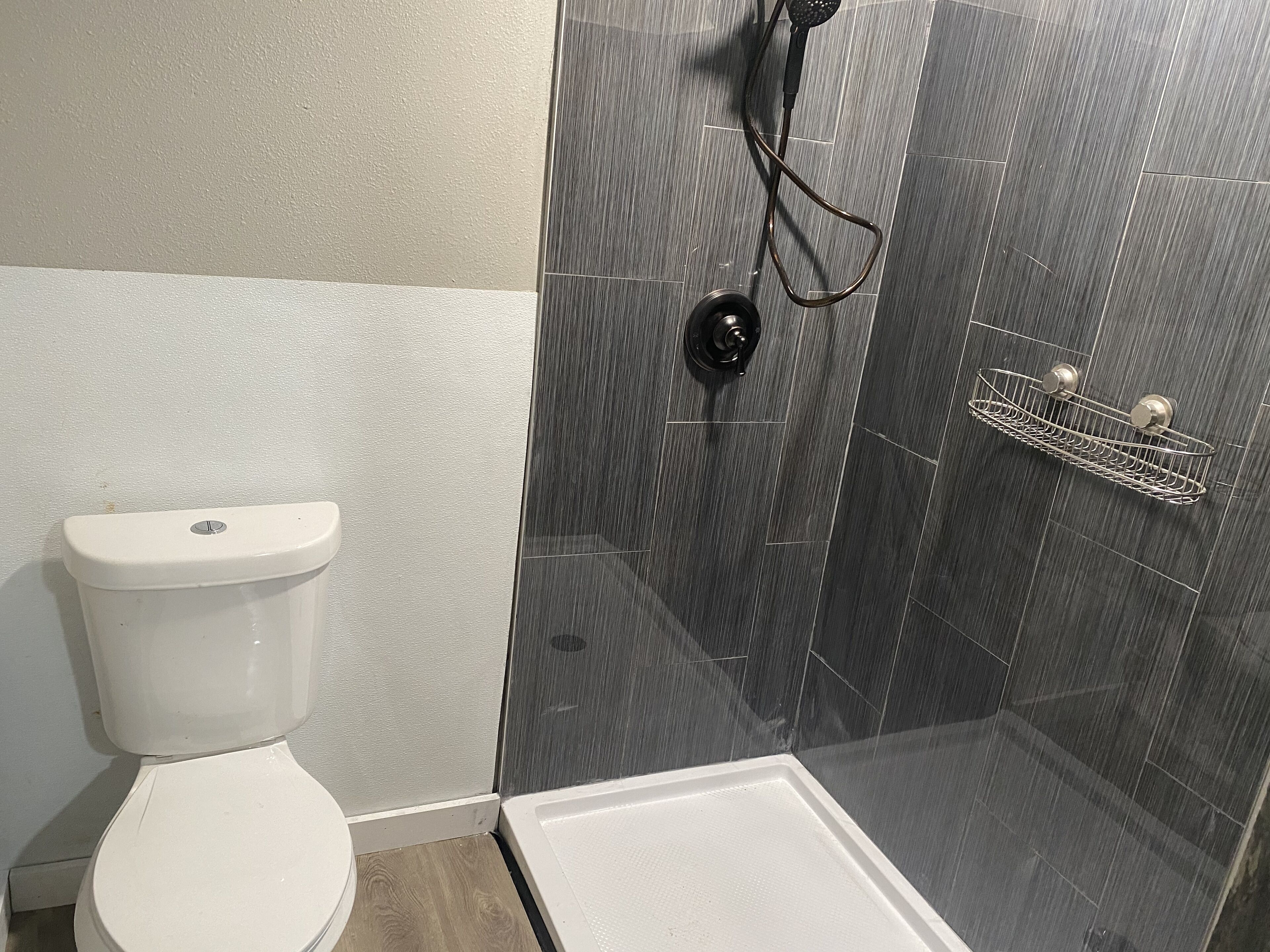 Een douche, handdoeken, zeep, toiletpapier