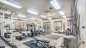 A gym with various exercise equipment, large windows, and a ceiling fan. - Safe Privately gated fully furnished 1 bedroom, 1 bath, Condo in prime location!  (Las Vegas)