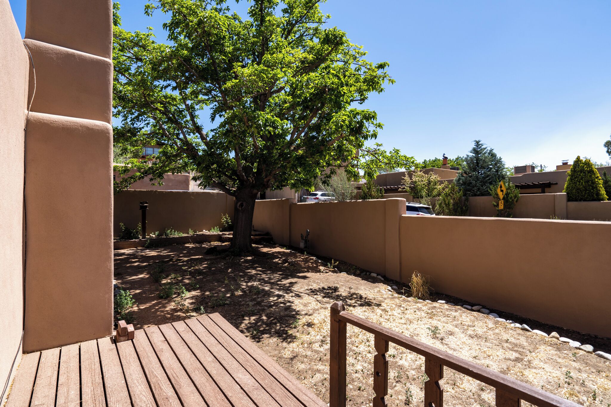A wooden deck with a tree in the background.