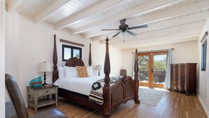A spacious bedroom with a four-poster bed, a ceiling fan, and a large window with a view of the outdoors. - Rio Grande Retreat by Kokopelli Property Management (Santa Fe)