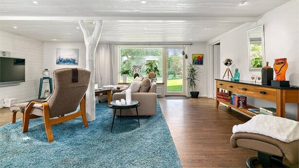 Amplia sala de estar con un ventanal grande, un sofá, un sillón y una mesa de centro.